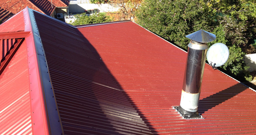 Red, steel roof with plumbing.
